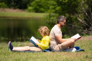 parent and child reading outside