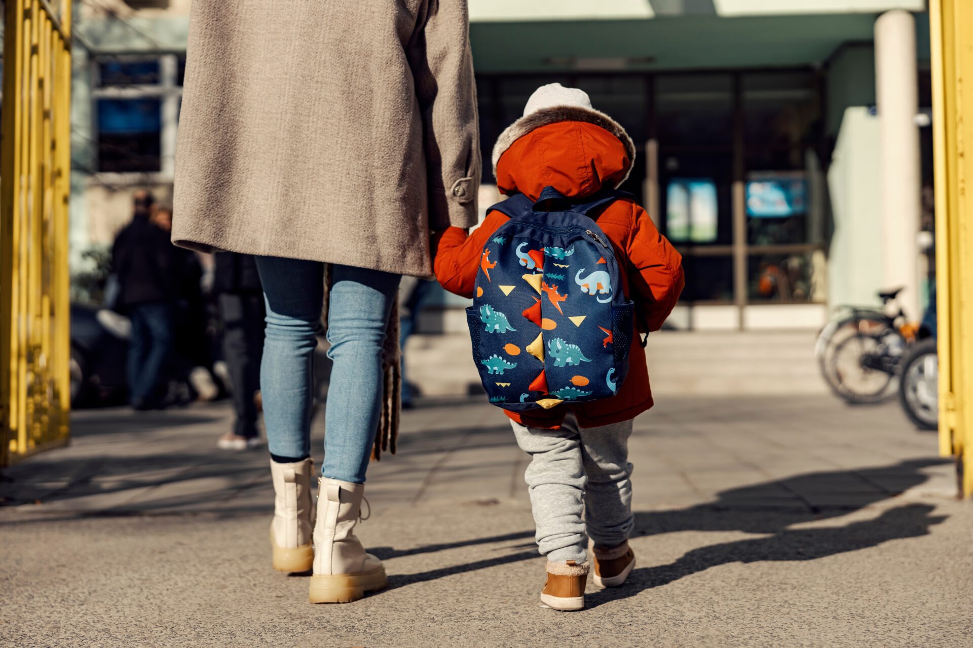 mother and child walking to school in winter